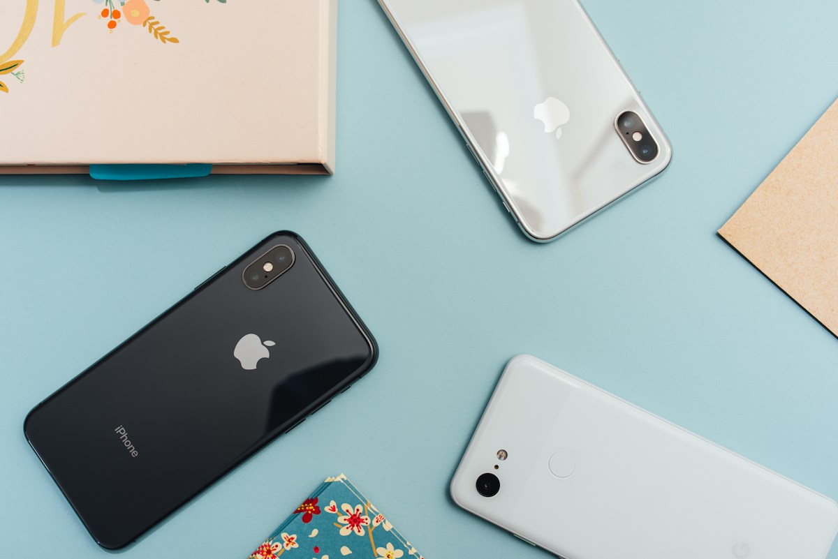 Several smartphones arranged on a pastel work surface